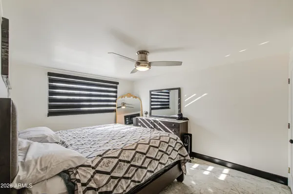 a bedroom with a bed and a ceiling fan