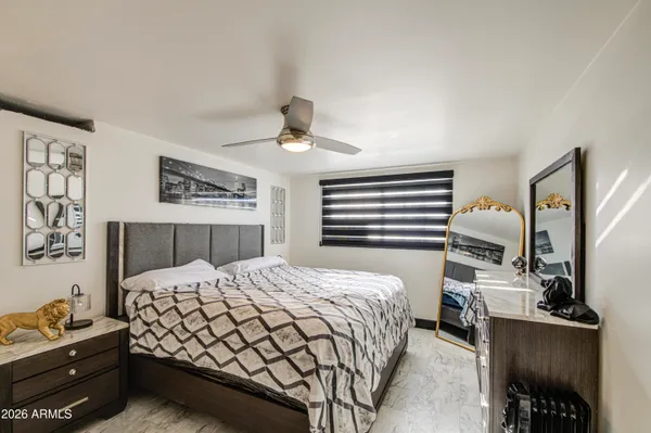 a bedroom with a bed dresser and wooden floor