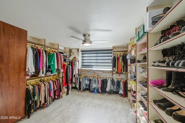 a view of walk in closet with clothes