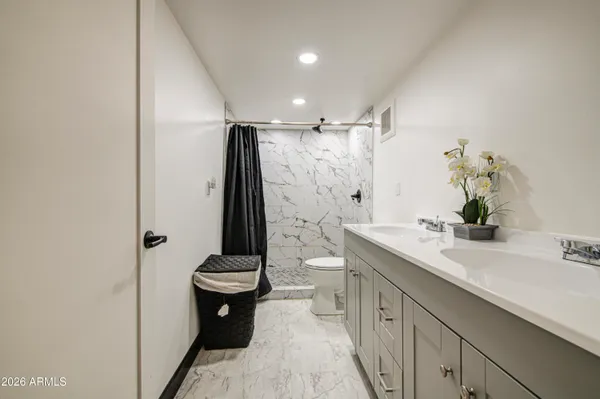 a bathroom with a sink a toilet and shower