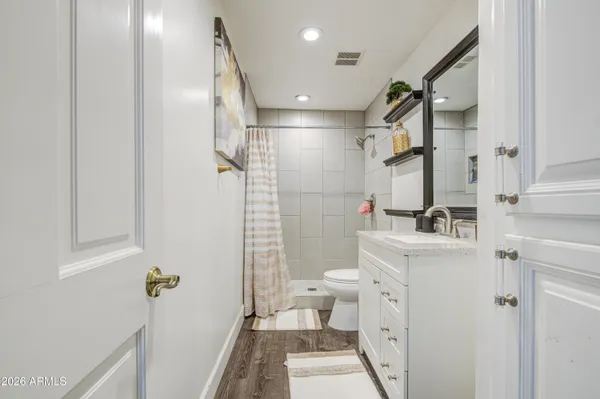 a bathroom with a sink a toilet and shower