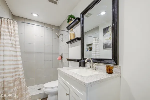 a bathroom with a sink a toilet and shower