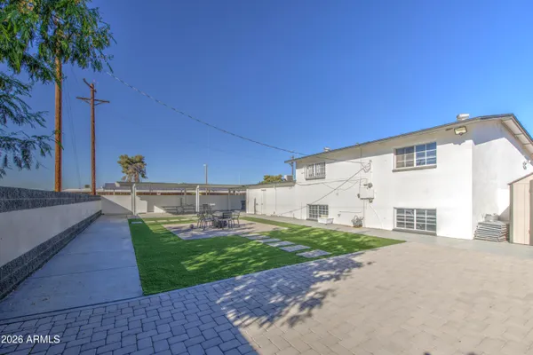 a view of a house with backyard and sitting area