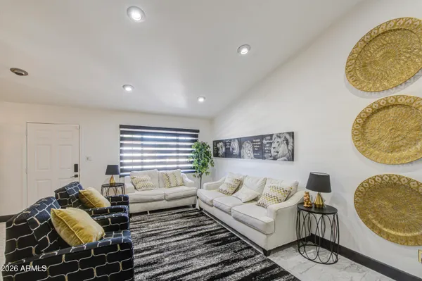 a living room with furniture and a wooden floor