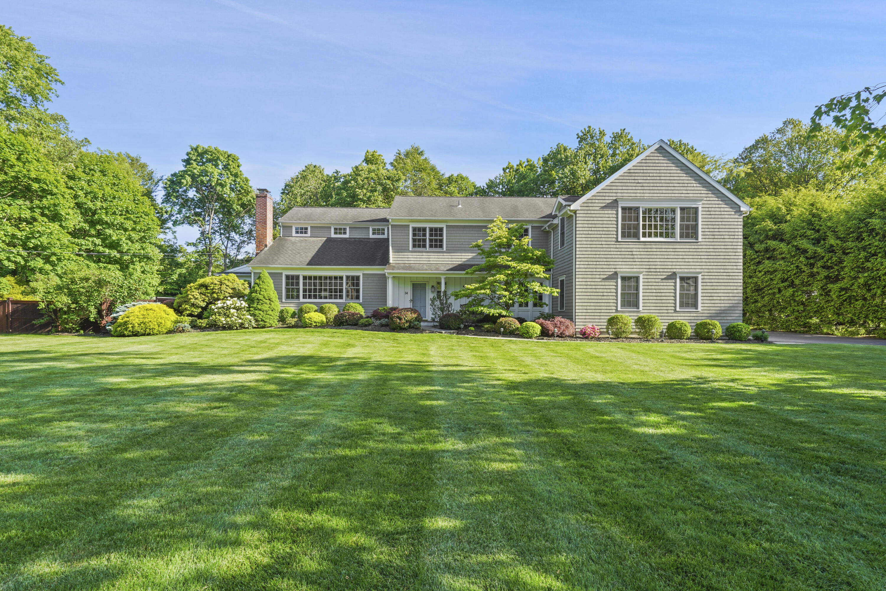 a front view of a house with a yard and trees