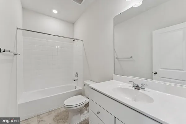 a bathroom with a sink a toilet and a large mirror