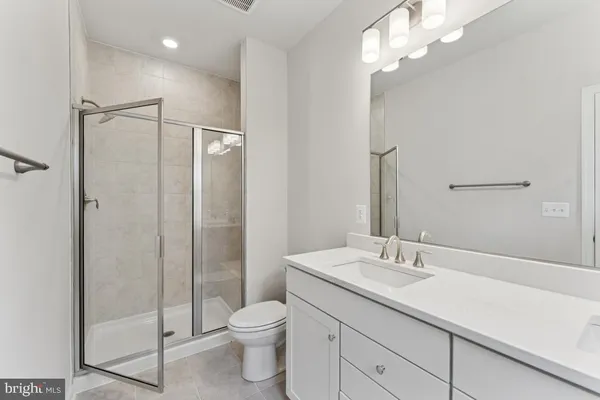 a bathroom with a shower sink vanity mirror and toilet