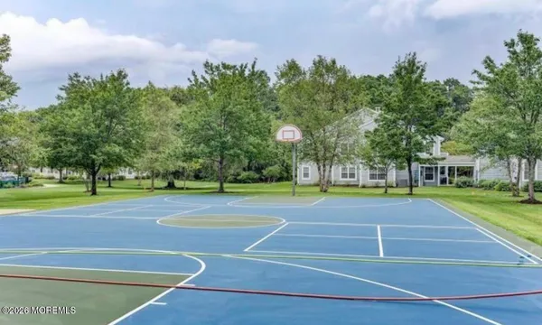 a view of a tennis ground with large trees