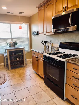 a kitchen with stainless steel appliances granite countertop a stove a sink and a microwave