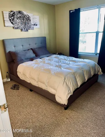 a large bed sitting in a bedroom next to a window