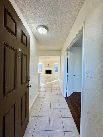 a hallway view with stainless steel appliances granite countertop a refrigerator and a sink
