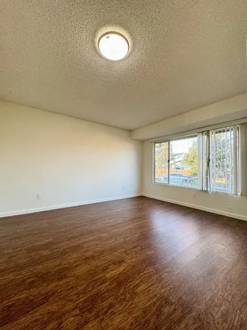 a view of a room with wooden floor and window