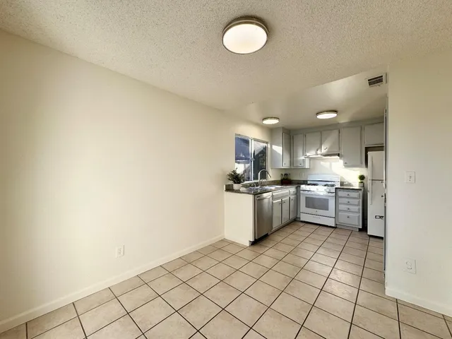 a kitchen with a sink a counter top space cabinets and stainless steel appliances