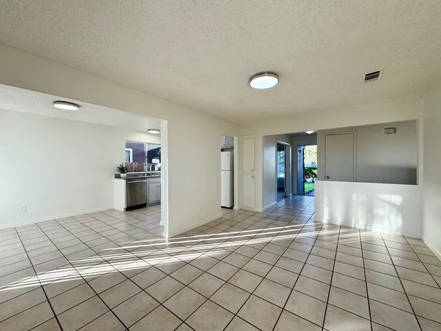 a view of a kitchen with kitchen island granite countertop a refrigerator and a stove top oven