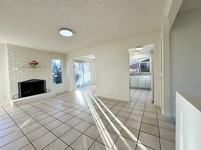 a view of empty room with fireplace and windows