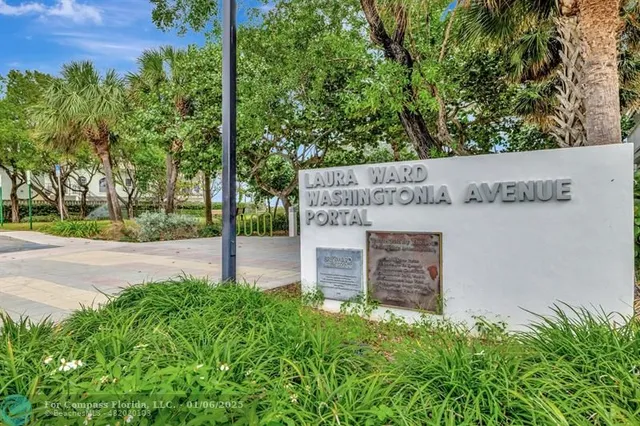 a view of a house with a small yard and a large tree