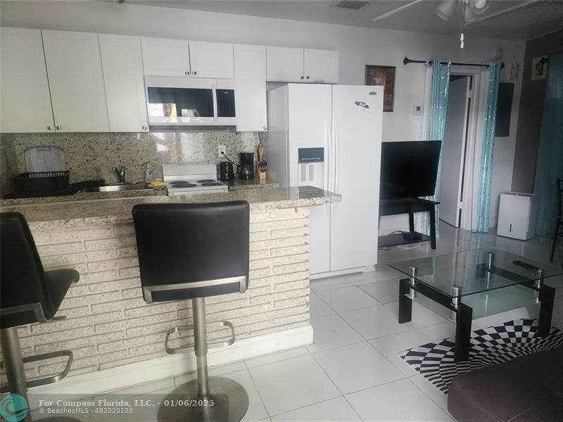 4548 North Ocean Drive, Unit 4 Lauderdale-by-the-Sea, FL 33308 - Photo 43 of 48 a kitchen with stainless steel appliances granite countertop a stove a refrigerator and a stove