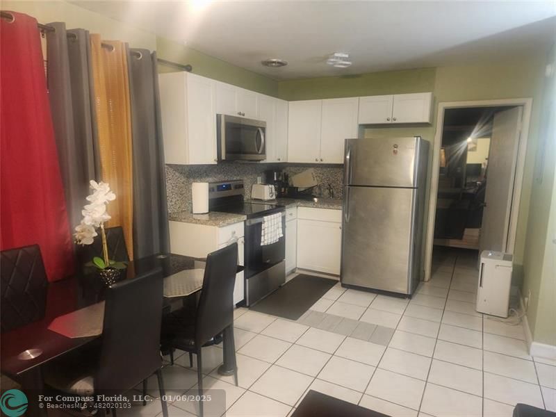 4548 North Ocean Drive, Unit 4 Lauderdale-by-the-Sea, FL 33308 - Photo 46 of 48 a kitchen with stainless steel appliances a refrigerator sink and cabinets