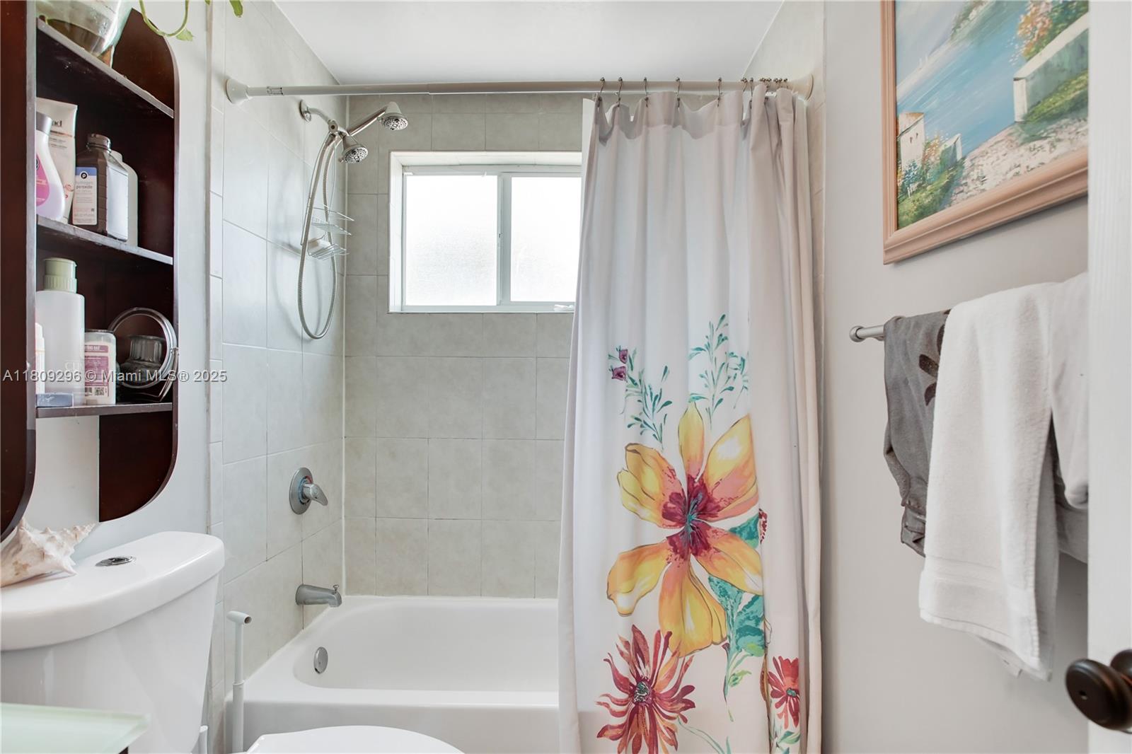 3101 Southwest 27th Avenue, Unit 203 Miami, FL 33133 - Photo 13 of 25 a bathroom with a bathtub and a shower curtain