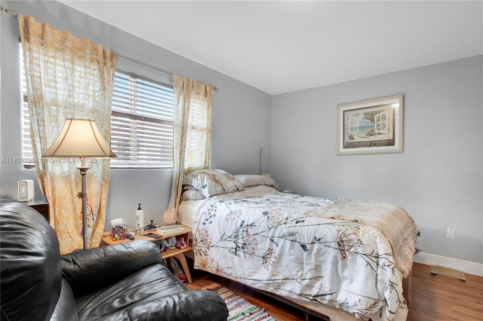 3101 Southwest 27th Avenue, Unit 203 Miami, FL 33133 - Photo 14 of 25 a bedroom with a bed and wooden floor