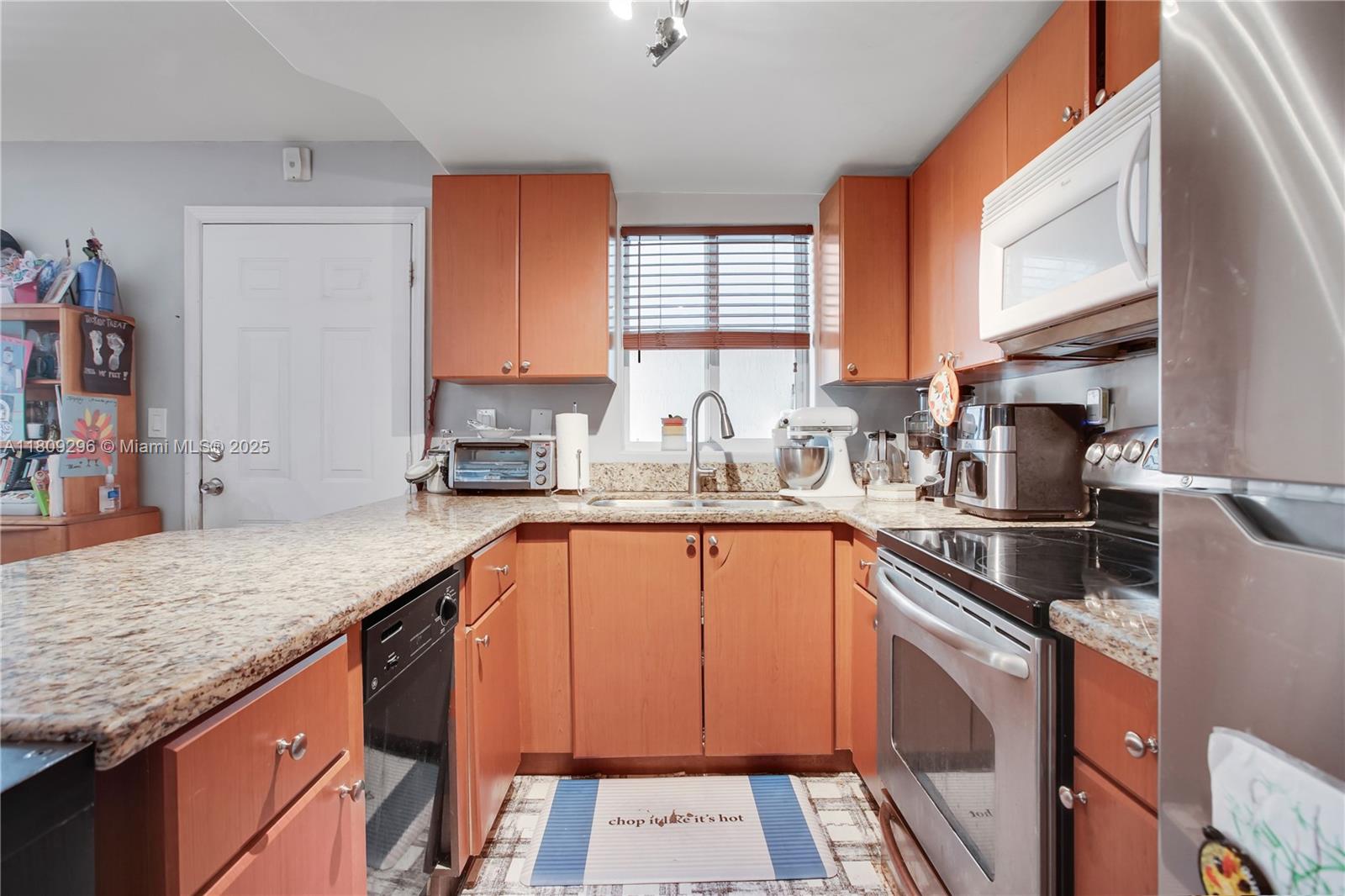 3101 Southwest 27th Avenue, Unit 203 Miami, FL 33133 - Photo 6 of 25 a kitchen with stainless steel appliances granite countertop a sink stove and cabinets