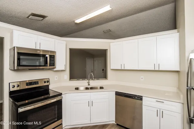 a kitchen with a sink stove and microwave