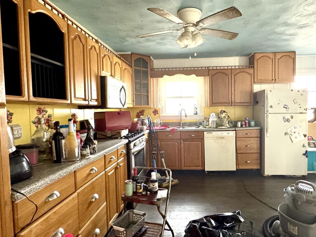 613 West Main Street Crowley, TX 76036 - Photo 11 of 30 Kitchen with stainless steel appliances, wood finish cabinetry, ceiling fan, glass insert cabinets, and dark wood-style flooring