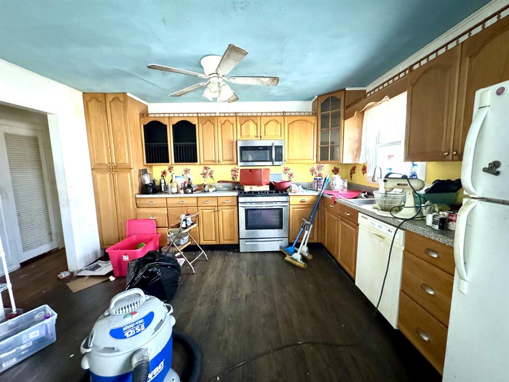 613 West Main Street Crowley, TX 76036 - Photo 12 of 30 Kitchen featuring stainless steel appliances, dark wood finished floors, glass fronted cabinets, a ceiling fan, and light countertops