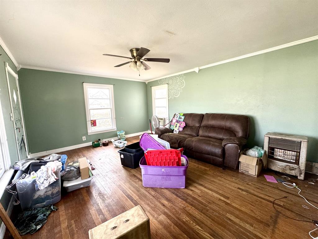 613 West Main Street Crowley, TX 76036 - Photo 8 of 30 Living area with wood-type flooring, heating unit, ornamental molding, and a ceiling fan