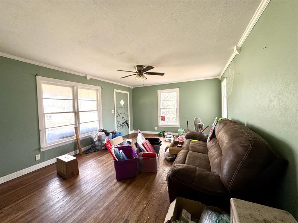 613 West Main Street Crowley, TX 76036 - Photo 9 of 30 Living room featuring ornamental molding, wood-type flooring, a textured ceiling, and ceiling fan