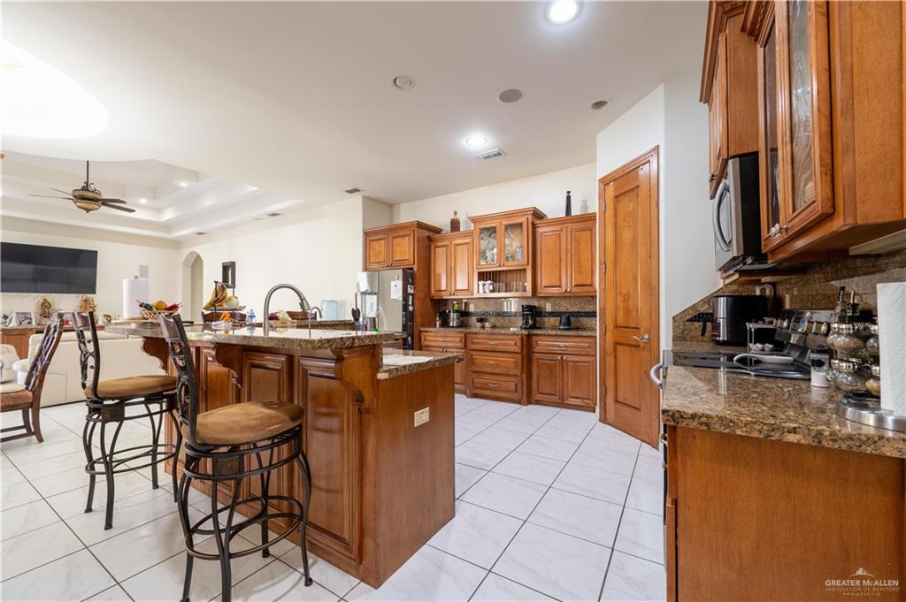 3801 South L Street McAllen, TX 78503 - Photo 15 of 38 a kitchen with stainless steel appliances granite countertop a refrigerator a sink a stove and island