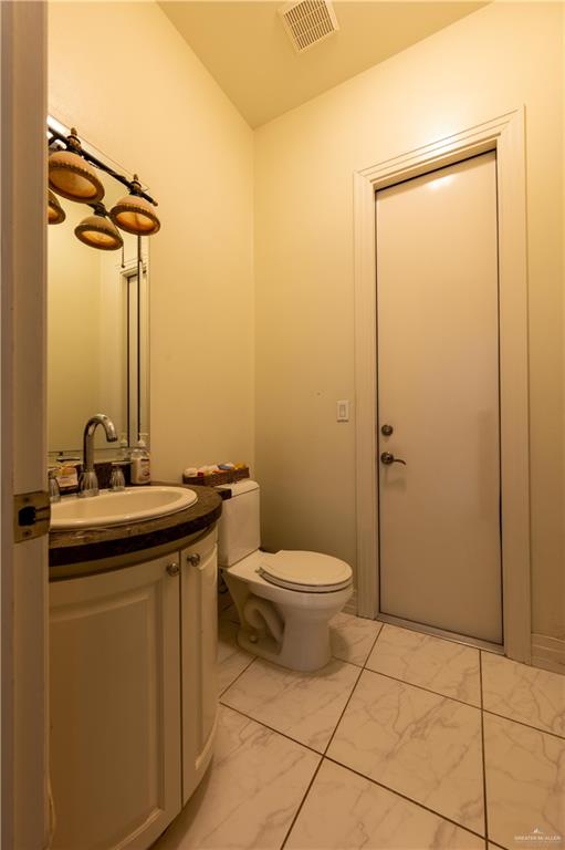 3801 South L Street McAllen, TX 78503 - Photo 6 of 38 a bathroom with a toilet a sink and mirror
