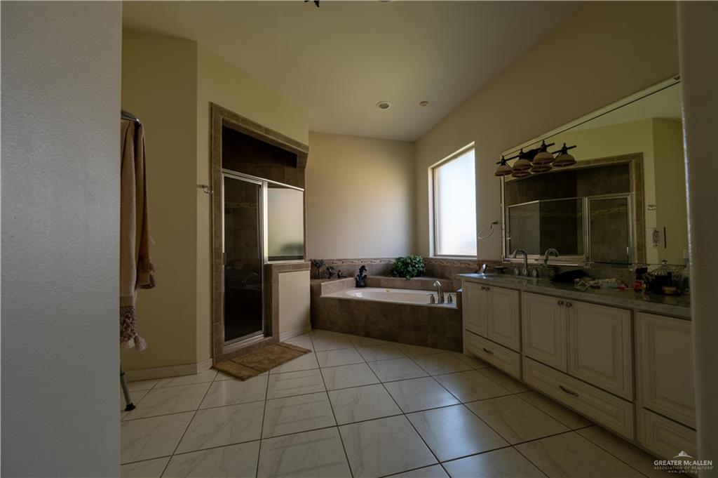 3801 South L Street McAllen, TX 78503 - Photo 8 of 38 a large bathroom with a sink a large mirror and a bathtub