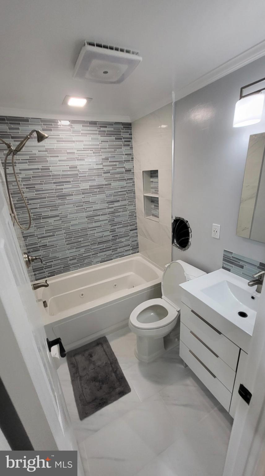 8001 Postoak Road Potomac, MD 20854 - Photo 7 of 30 a bathroom with a toilet a sink and bathtub