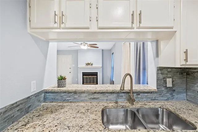 a kitchen with granite countertop a sink and a stove
