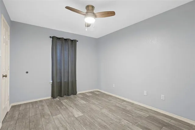 an empty room with a ceiling fan and carpet