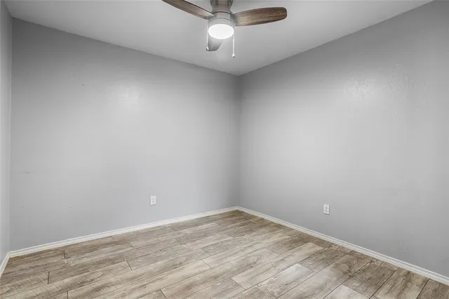 an empty room with a ceiling fan and window