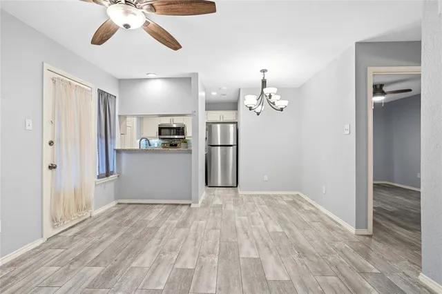 wooden floor in an empty room with a kitchen