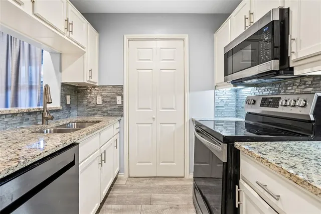 a kitchen with stainless steel appliances granite countertop a stove microwave and sink