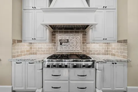 a kitchen with granite countertop a stove and a cabinets