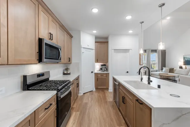 a kitchen with stainless steel appliances a sink stove top oven and refrigerator