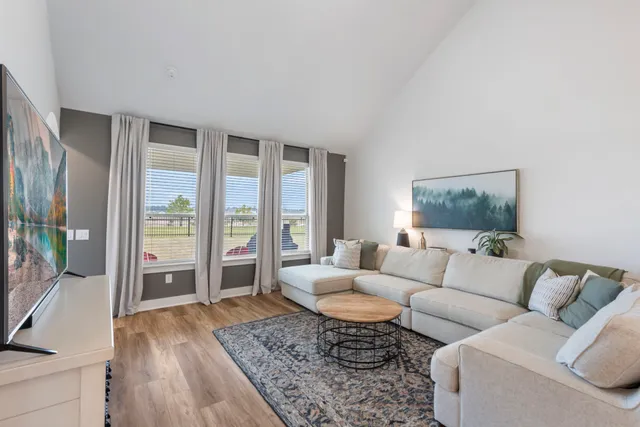 a living room with furniture and a floor to ceiling window
