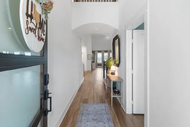 a view of a hallway with wooden floor and entryway