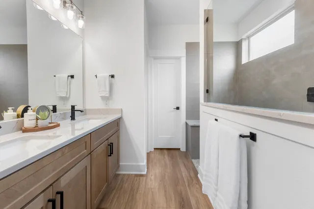 a spacious bathroom with a granite countertop sink a toilet a mirror and shower