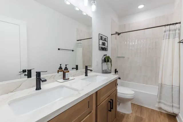 a bathroom with a granite countertop sink a toilet and shower