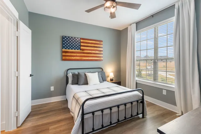 a bedroom with a large bed chandelier and a window
