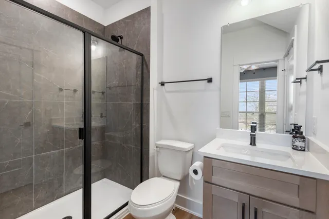 a bathroom with a sink a toilet and shower