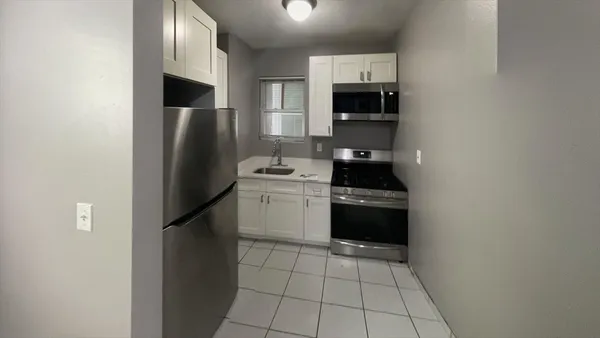 a kitchen with a sink appliances and cabinets