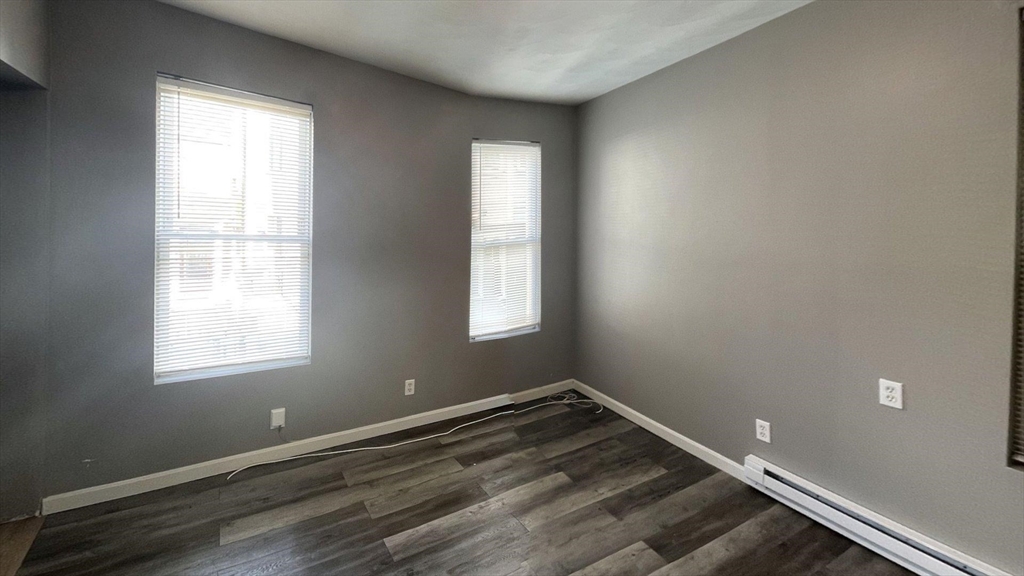 8 Cheever Court, Unit 1 Boston, MA 02128 - Photo 2 of 16 an empty room with wooden floor and windows