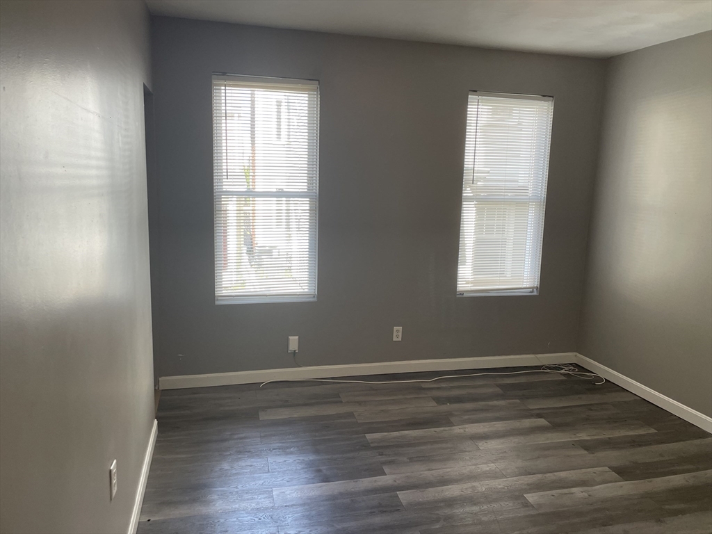 8 Cheever Court, Unit 1 Boston, MA 02128 - Photo 8 of 16 an empty room with wooden floor and windows